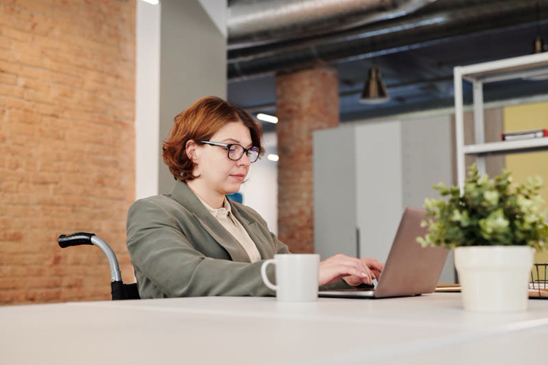 Professional woman in a wheelchair working confidently in an office environment, embodying employment empowerment
